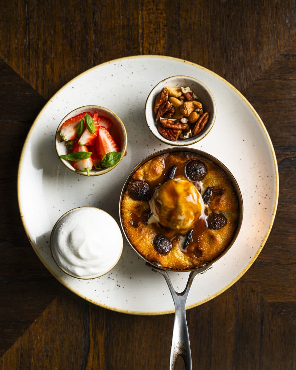 Dessert gastronomique avec glace et fruits sur table boisée