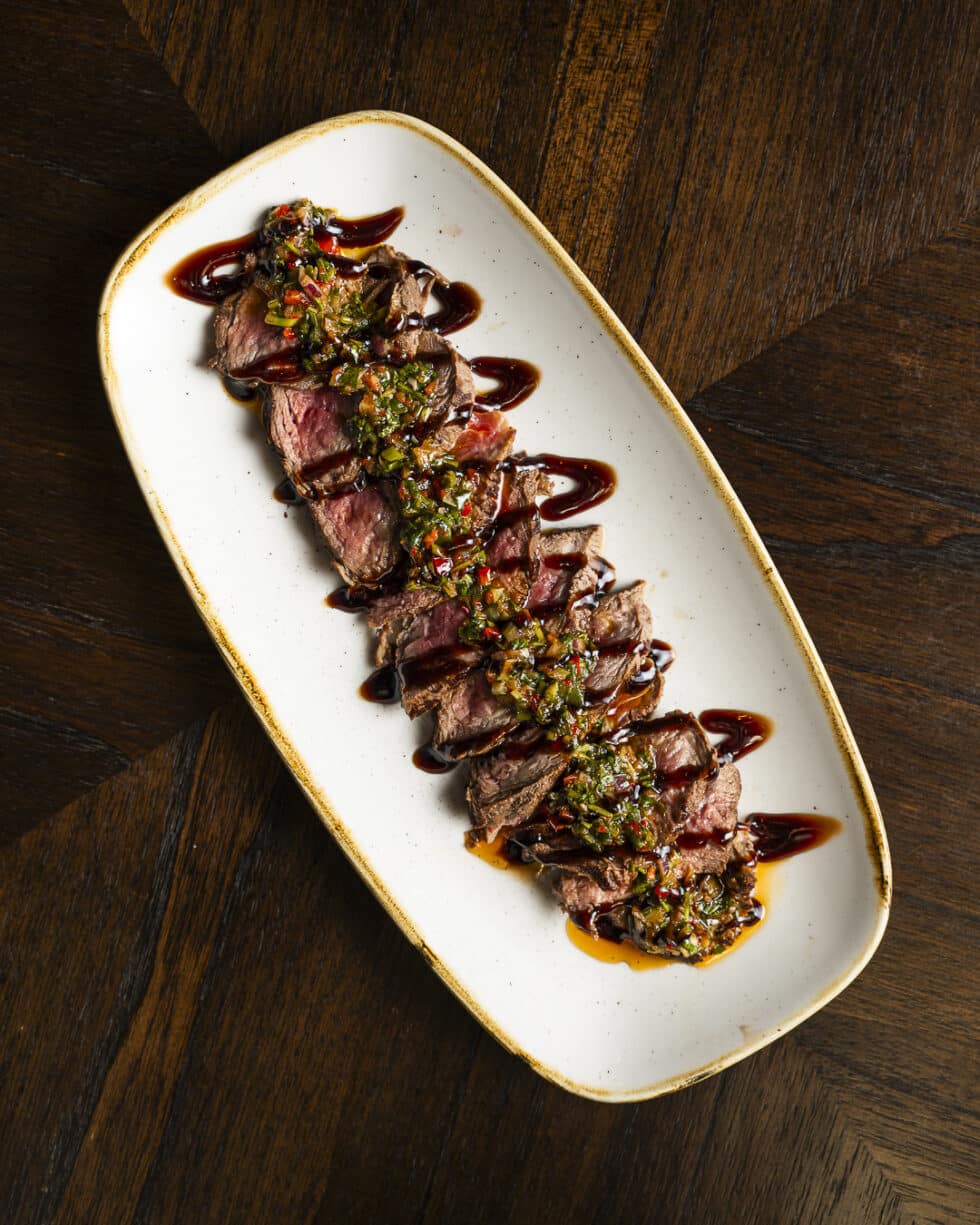 Steak tranché avec sauce épicée sur assiette ovale