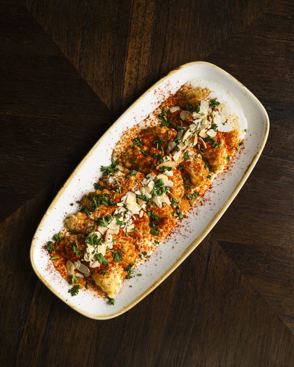 Plat de croquettes garnies de sauce et amandes